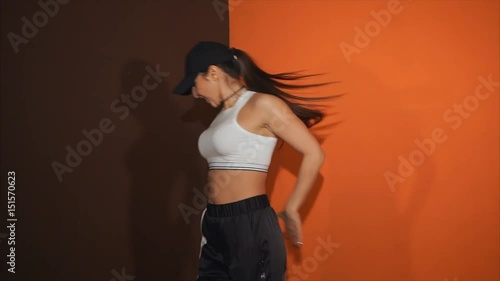 The adult girl shows movements with a body under active music. The dancer trains hip hop - the most fashionable and popular trend of youth culture photo