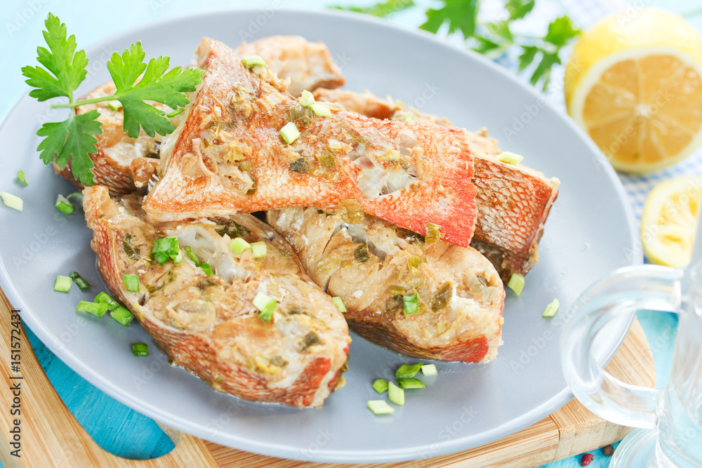 Steamed snapper (pacific ocean perch, sea bass, ruby perch) with soy sauce, lemon, ginger and parsley in Asian style