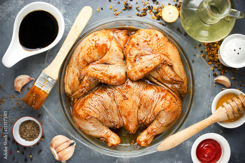 Raw marinated whole chicken for BBQ with soy sauce, honey, garlic, spices