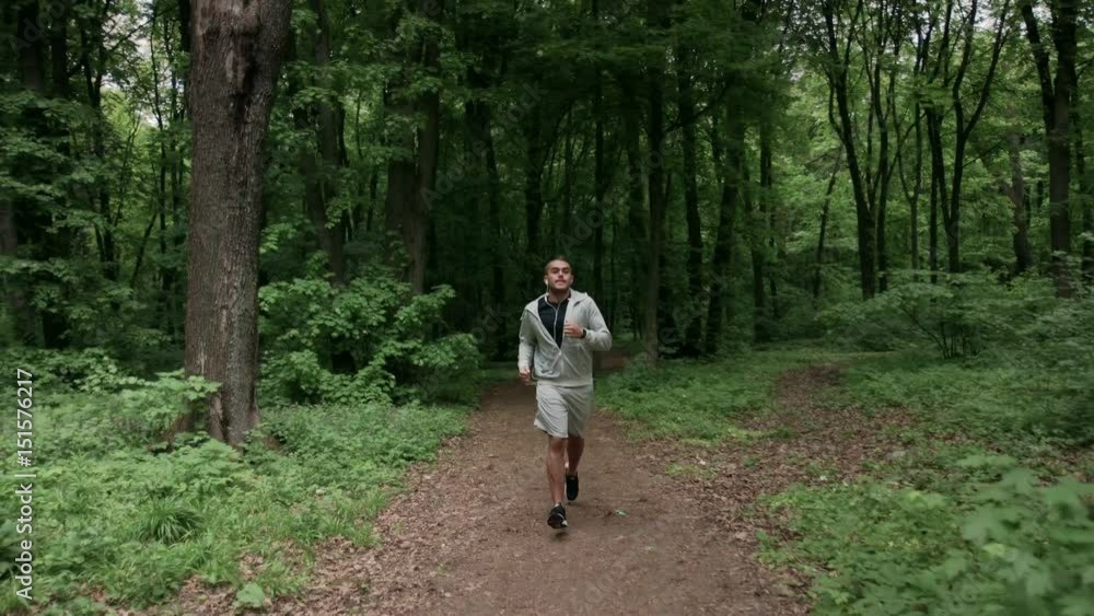 Lone runner in wintry wood, slow motion shot Lone runner in wintry wood, slow motion shot