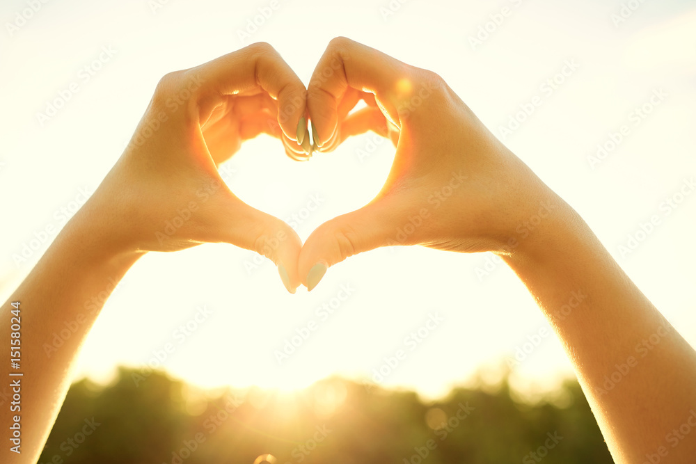 Obraz premium Hands in shape of the heart in sun.