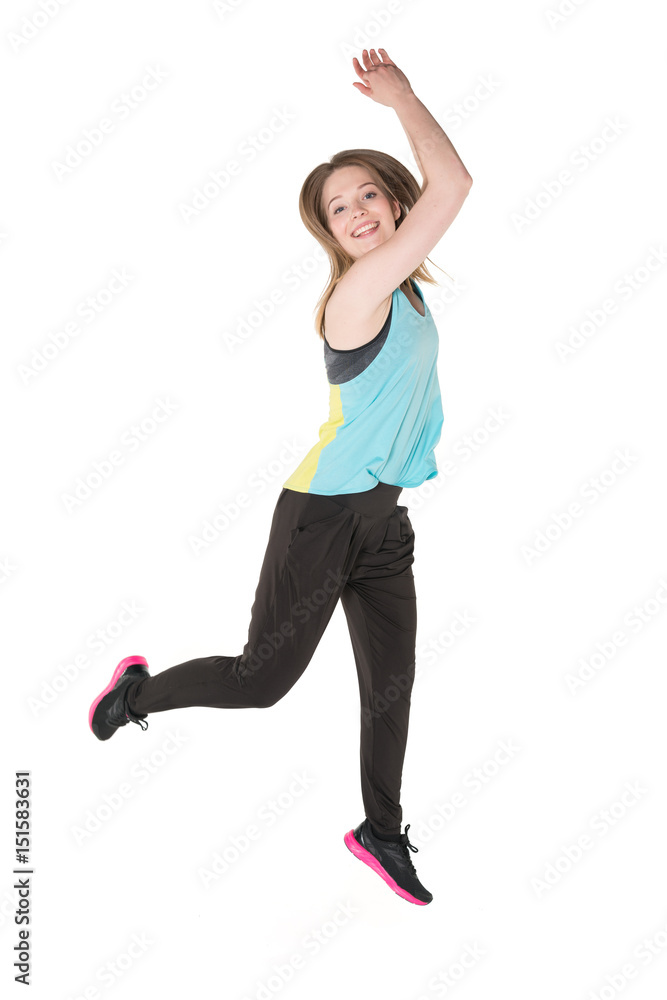 Young, pretty natural looking girl in sport t -shirt and jogging pants having fun dancing. Full body studio shot, pure white background.