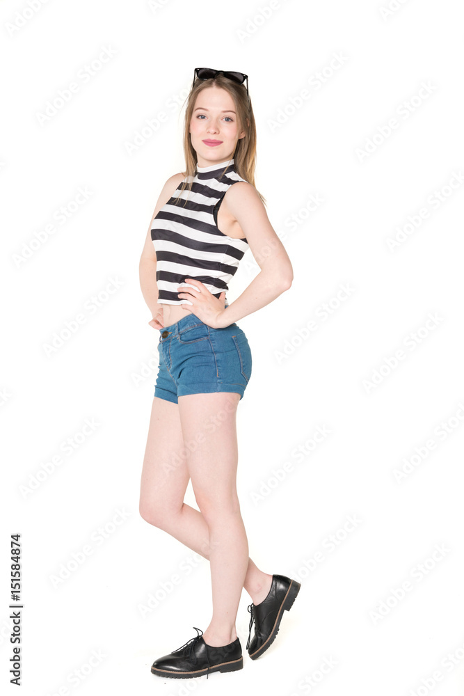 Young, pretty teenager standing with blue shorts and colorful bikini top. studio shot on pure isolated white background Young, pretty teenager standing with blue shorts and colorful bikini top. studio shot on pure isolated white background