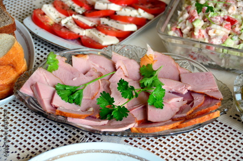 Serving a festive table, slices of ham on a plate