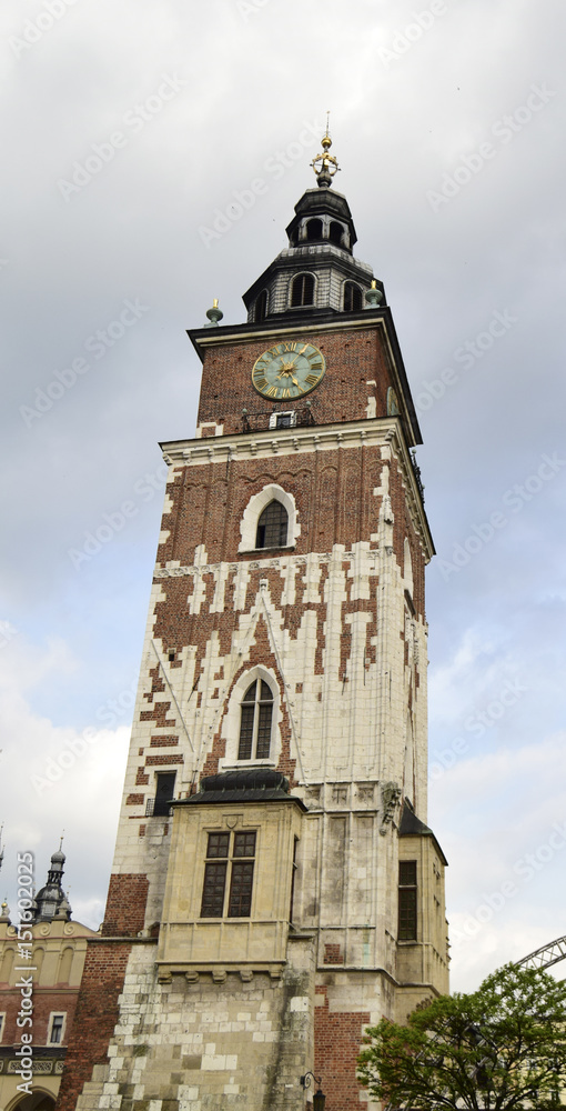 Town hall tower in the aged city of Krakow, Poland. The tower is constructed of a brick and decorated with stone facing from white limestone.