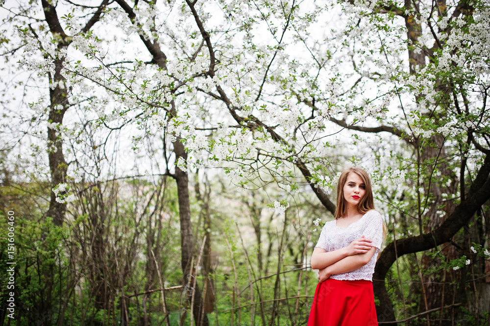 Portrait of beautiful girl with red lips at spring blossom garden, wear on red dress and white blouse. Portrait of beautiful girl with red lips at spring blossom garden, wear on red dress and white blouse.