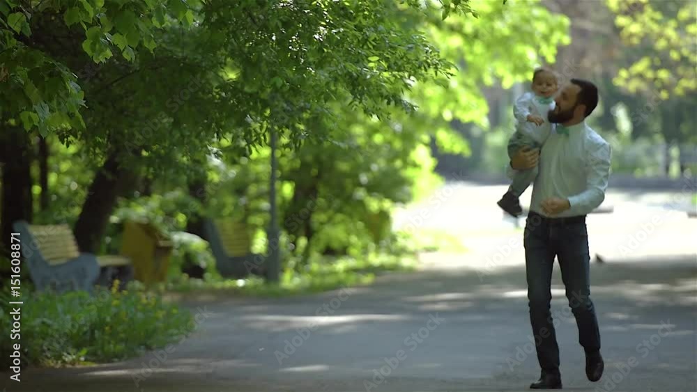 Dad and son are running along the path in the park and laughing. Father's Day. Dad and son are running along the path in the park and laughing. Father's Day.