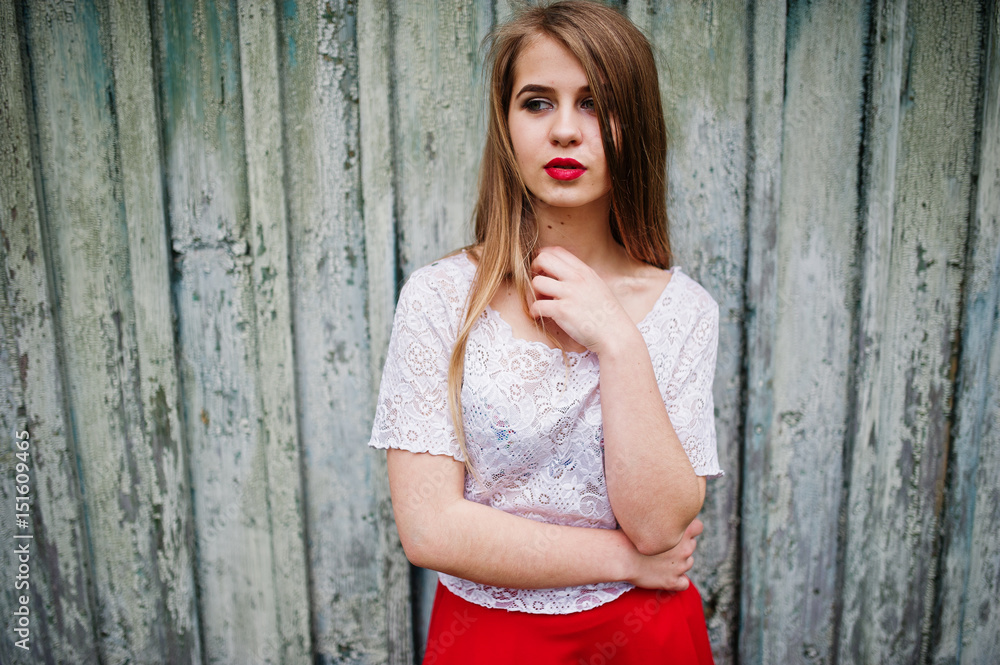 Fototapeta premium Portrait of beautiful girl with red lips against wooden background, wear on red dress and white blouse.