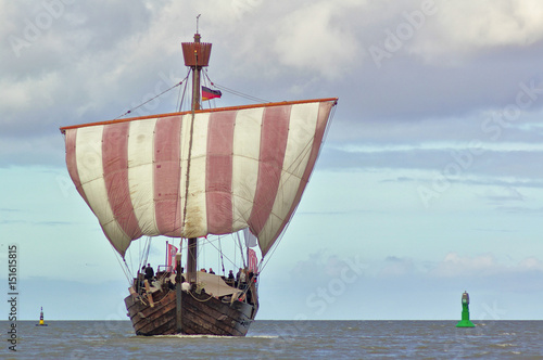 Hanseatic cog under sail with green and yellow buoy
