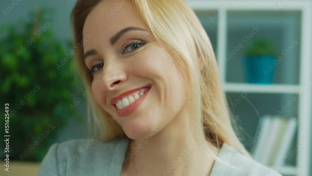 Portrait of beatiful blond business woman in glasses posing on camera, removing the glasess and smiling in office background. Close up. Portrait of beatiful blond business woman in glasses posing on camera, removing the glasess and smiling in office background. Close up.