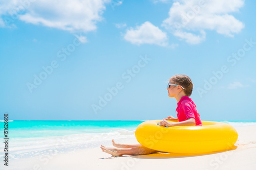 Adorable little girl with inflatable rubber circle have fun on the beach © travnikovstudio