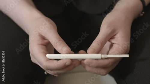 Anonymous female nervously checking a pregnancy test