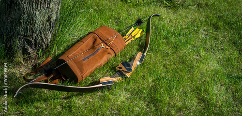 фотографія Traditional archery re-curve bow in the grass with quiver of arrows