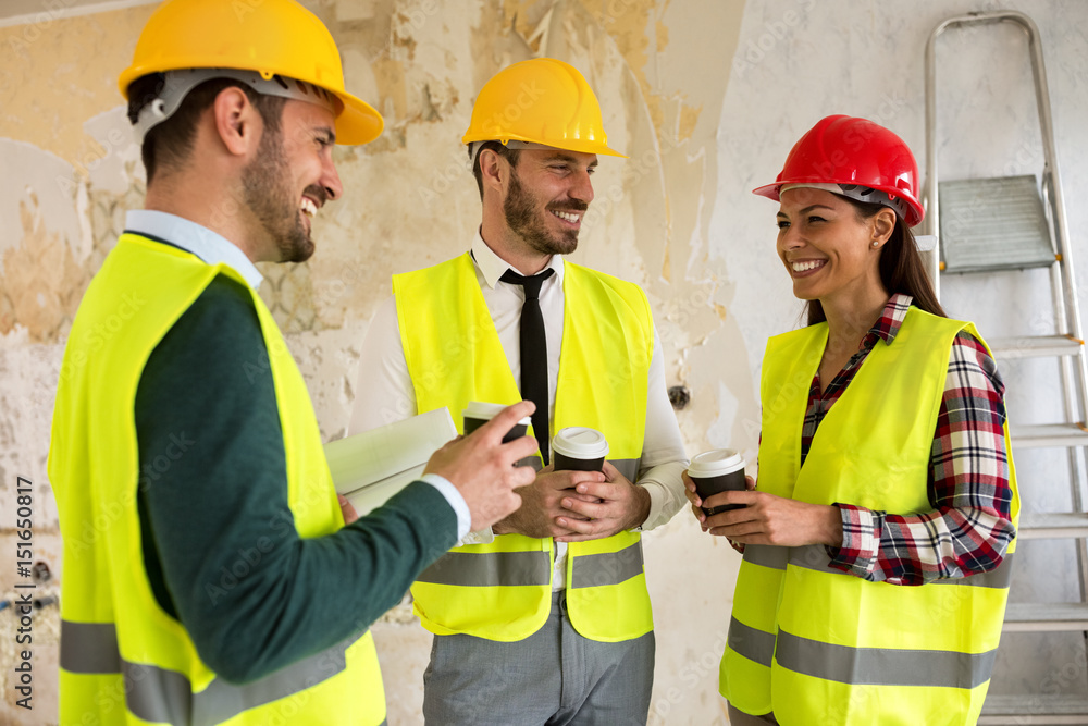 Group of architects talking on coffee break at construction site Group of architects talking on coffee break at construction site