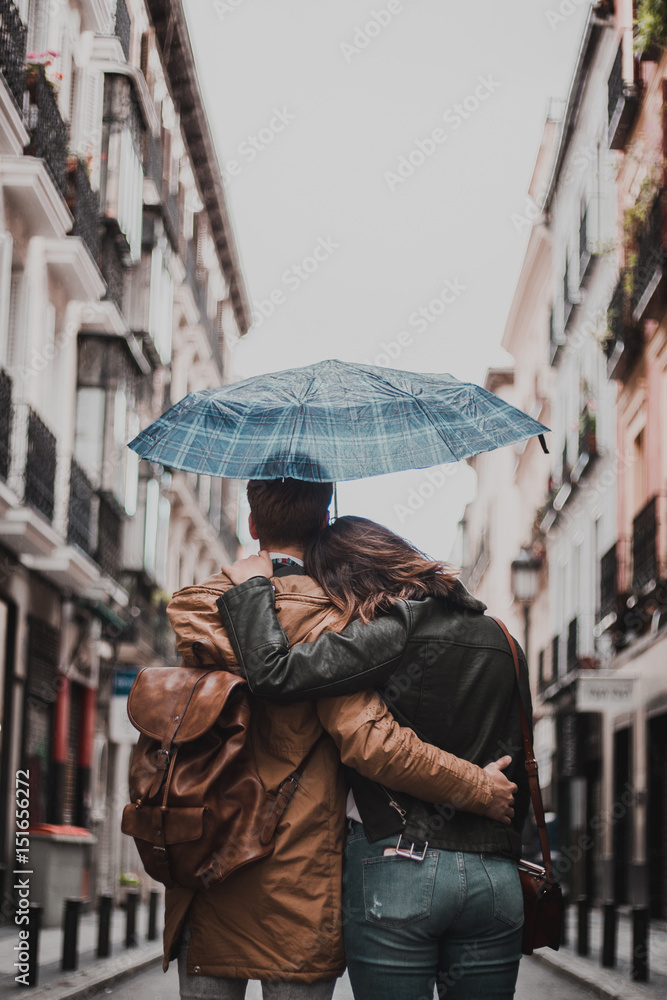 Couple in love on the street on a rainy day. Friends walking down the street