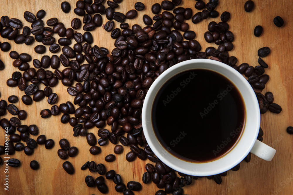 Black coffee and coffee bean on wood texture background. breakfast on morning or coffee time. Black coffee and coffee bean on wood texture background. breakfast on morning or coffee time.