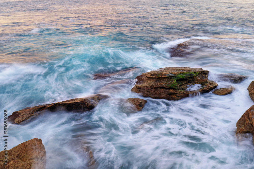 Obraz premium Water flow into coastal rocks.