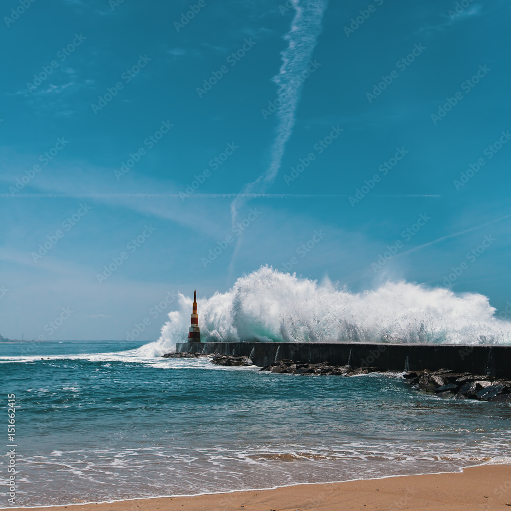 Powerful surf on the ocean coast, near the lighthouse. Porto, Portugal.