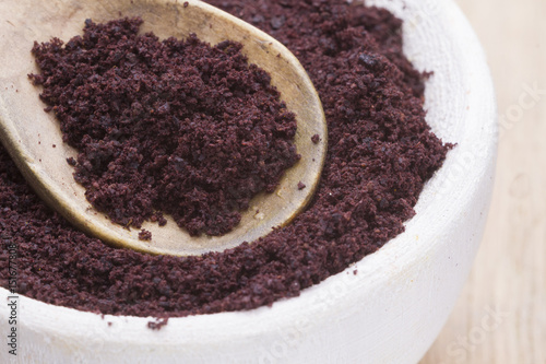 Acai powder Amazon fruit in container on wood