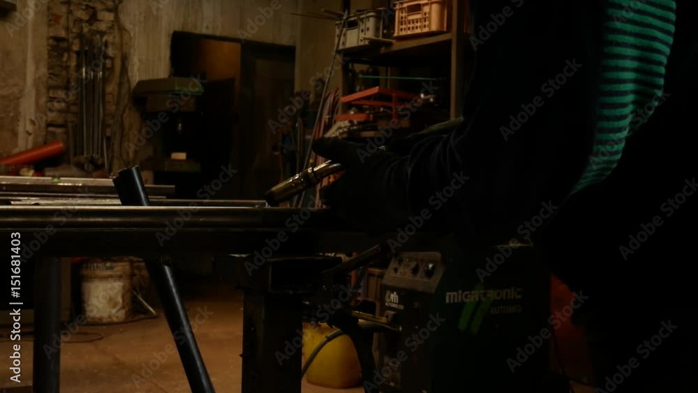 Worker Welds Iron Pipe in the Workroom. Worker Welds Iron Pipe in the Workroom.