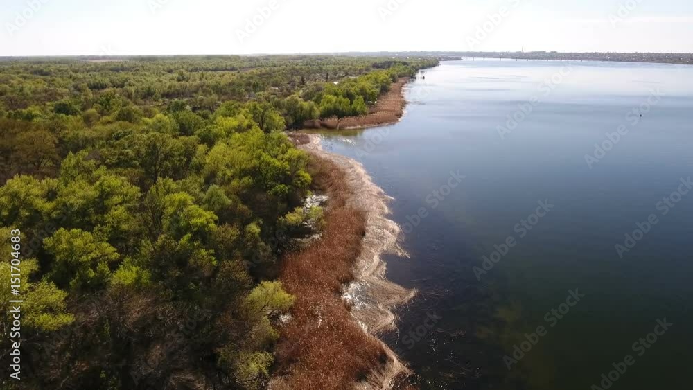 Astonishing aerial shot of the Dnipro river basin with sparkling waters, curvy river bank, wild greenary, forest boscages, small inflows, nice skyscape, in Ukraine in a sunny day in spring Astonishing aerial shot of the Dnipro river basin with sparkling waters, curvy river bank, wild greenary, forest boscages, small inflows, nice skyscape, in Ukraine in a sunny day in spring