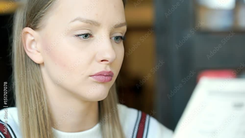 Pretty, young girl looks absorbed while reading menu, steadycam shot
Pretty, young girl looks absorbed while reading menu, steadycam shot