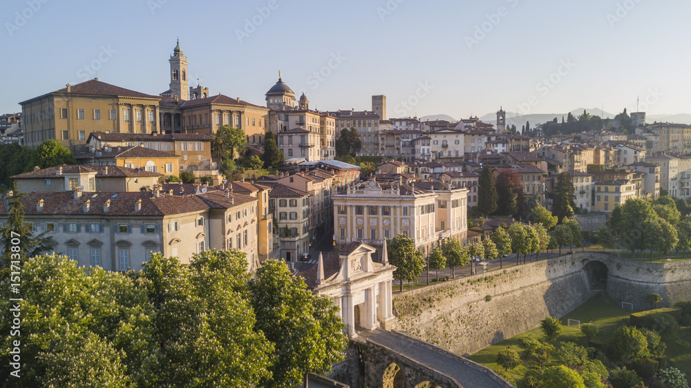 Drone aerial view of Bergamo - Old city (Città Alta). One of the beautiful city in Italy. Landscape on the old gate named Porta San Giacomo and historical buildings during a wonderful blu day