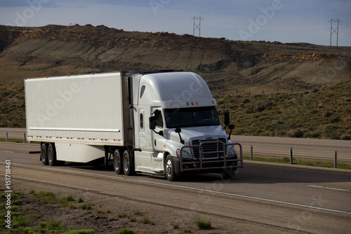 A white Freightliner Cascadia Semi-Tractor pulls a white trailer along Interstate 80 in Rural Wyoming on May 4th, 2017.