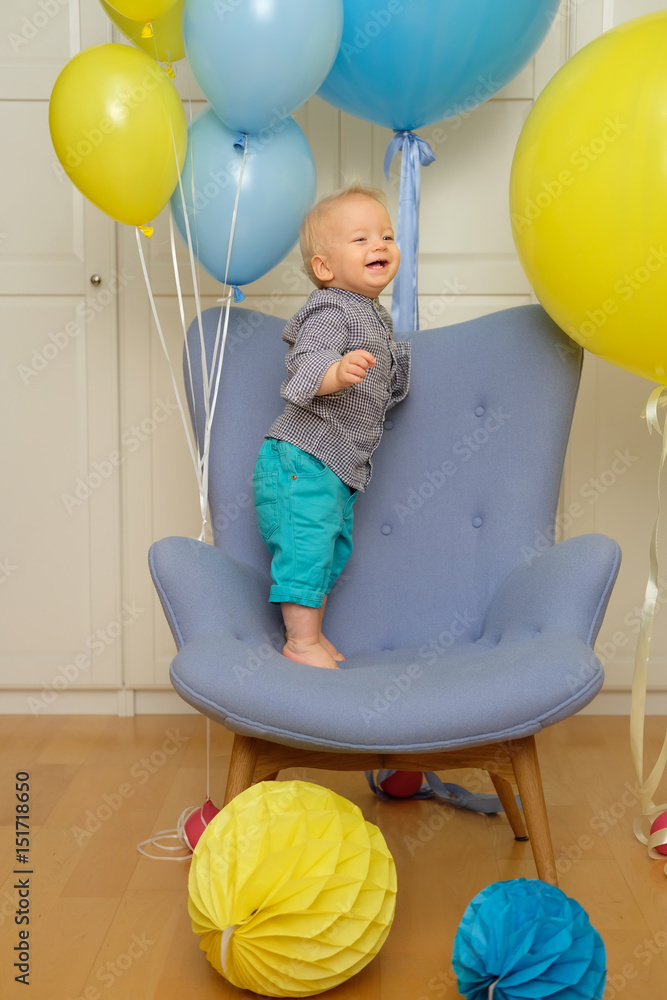 One year old baby boy first birthday. Toddler child sitting in