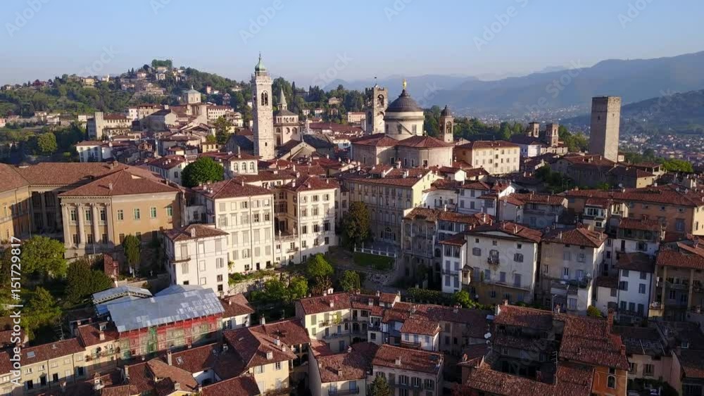 Drone aerial view of Bergamo - Old city (Città Alta). One of the beautiful city in Italy. Landscape on the city center, the main square and its historical buildings during a wonderful blu day Drone aerial view of Bergamo - Old city (Città Alta). One of the beautiful city in Italy. Landscape on the city center, the main square and its historical buildings during a wonderful blu day