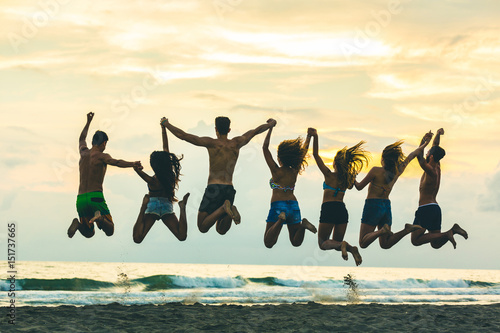Silhouette of friends jumping on the beach