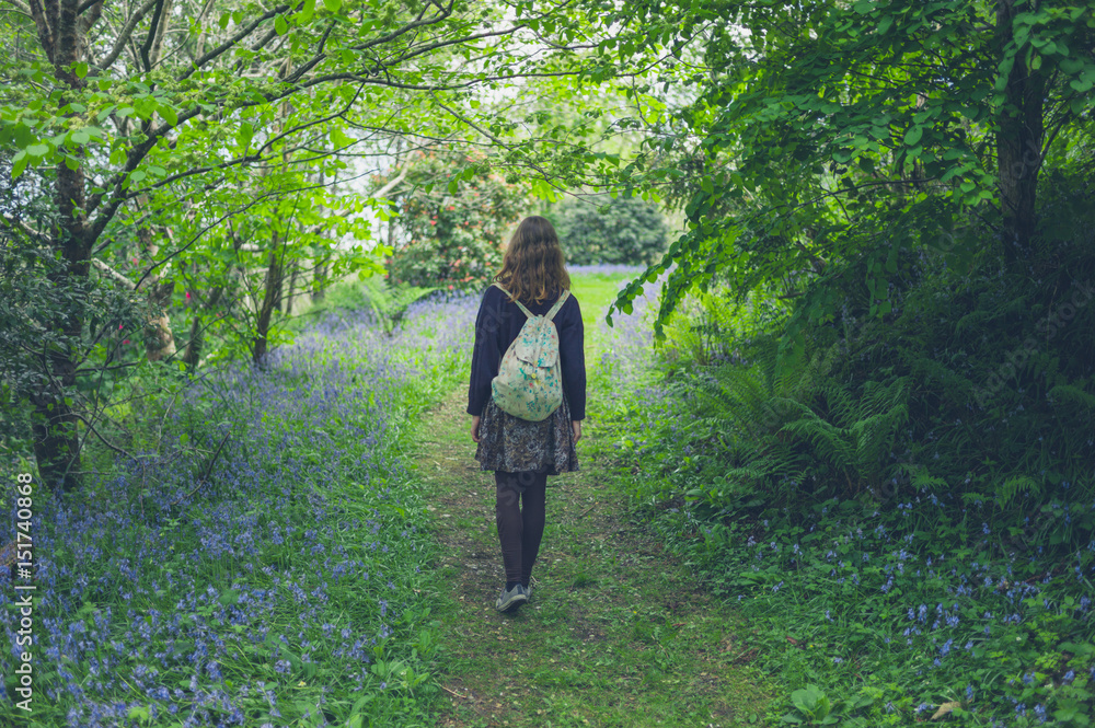 Woman walking in forest with bluebells Woman walking in forest with bluebells