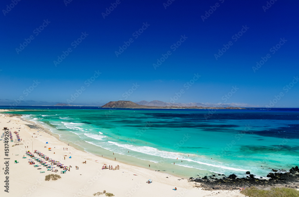 Panorama view of the islands of Lobos and Lanzarote seen from Corralejo Beach (Grandes Playas de Corralejo) on Fuerteventura, Canary Islands, Spain, Europe. Beautiful turquoise water & white sand.