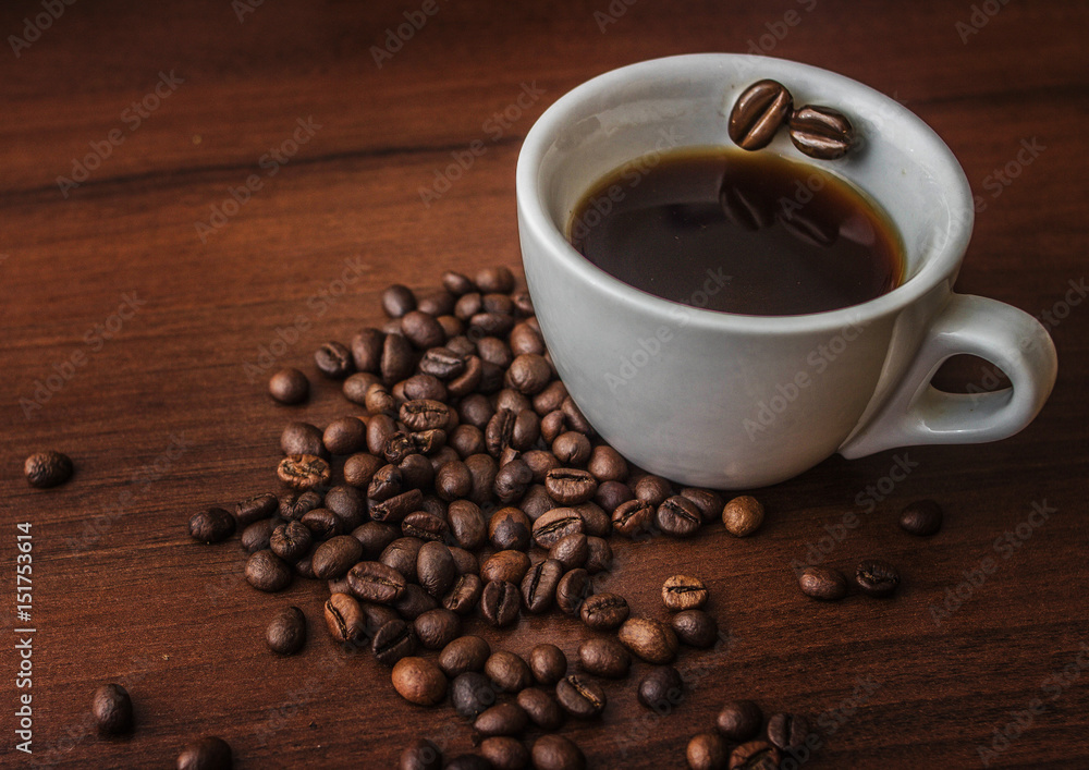 Cup with coffee on a tree with coffee beans