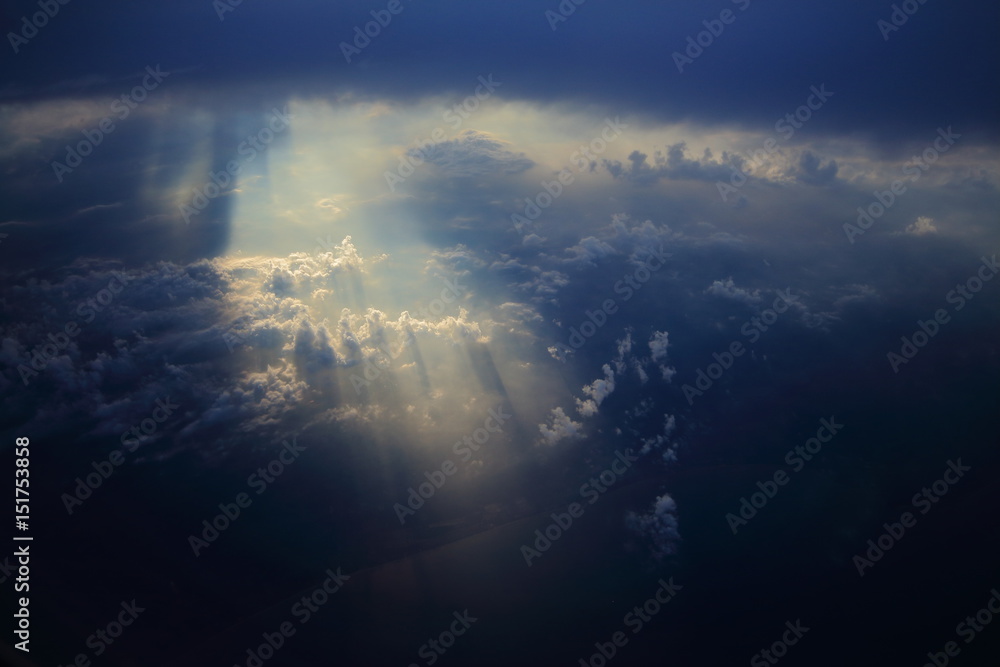 Rays of light shining through dark clouds on another cloud layer for ...