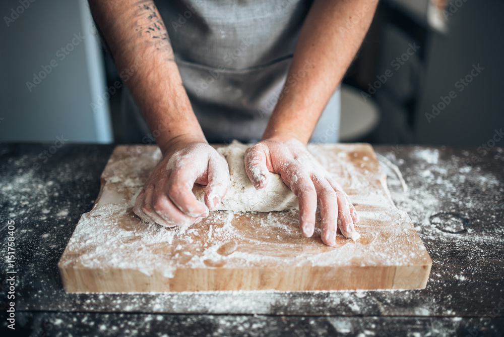 Baker hands kneading the dough with flour Baker hands kneading the dough with flour