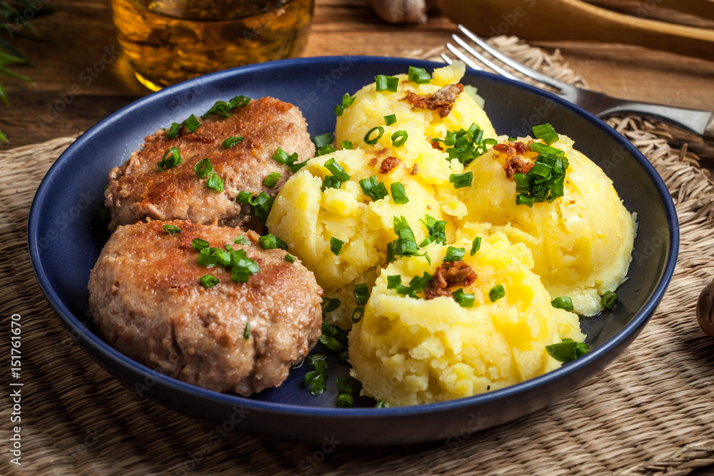 Meatballs served with boiled potatoes on a plate.