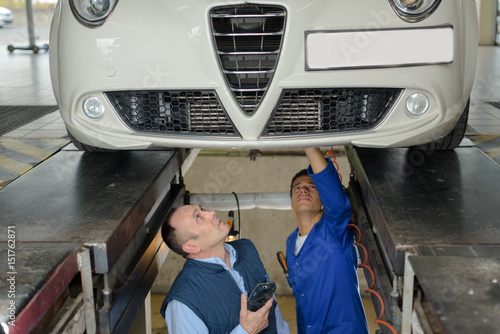 Fotografia Mechanics in pit underneath car