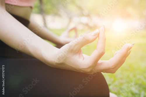 Yoga outdoors in summer park. young woman sits in lotus position zen gesturing. Concept of healthy lifestyle and relaxation © 88studio