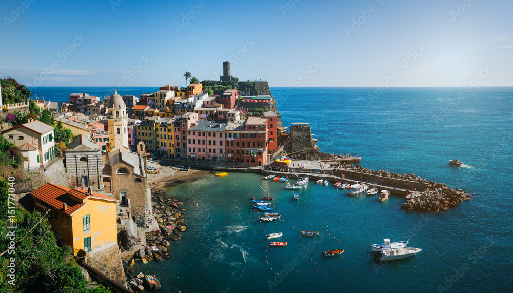 Panoramic overview of Vernazza village with colorful houses on bright summer sunny day, Cinque Terre National Park, La Spezia region, Liguria. Picturesque scene travel postcard.