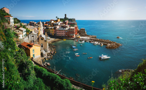 Panoramic overview of Vernazza village with colorful houses on bright summer sunny day, Cinque Terre National Park, La Spezia region, Liguria. Picturesque, scenic travel panorama postcard.