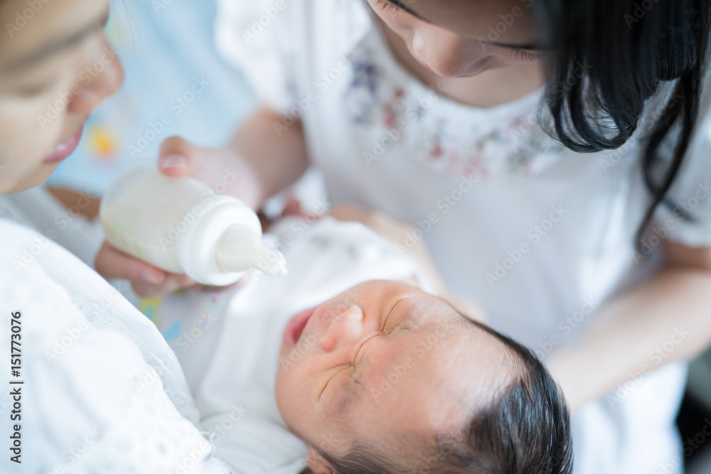 Mother and nuurse feeding mom milk to asian new born baby Mother and nuurse feeding mom milk to asian new born baby