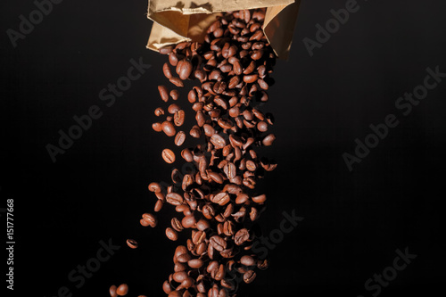 Kaffeebohnen fallen aus einer Tüte,schwarzer Hintergrund