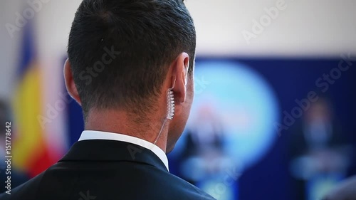 Detail with a bodyguard wearing in ear headset photo