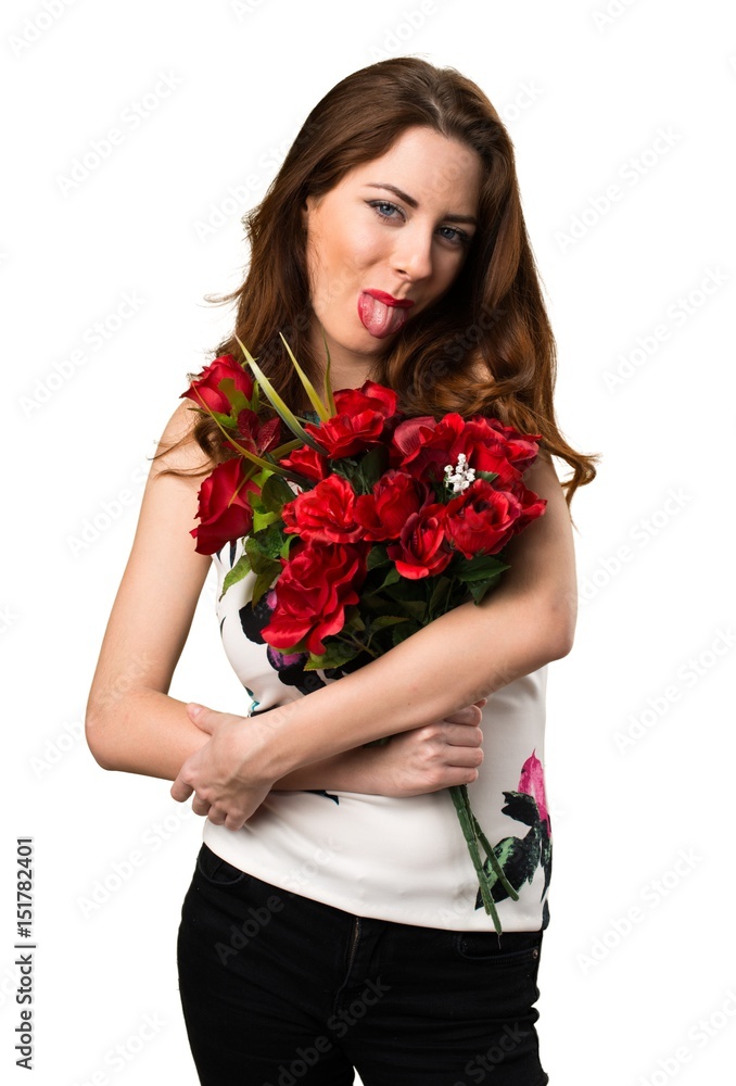 Beautiful young girl holding flowers taking out her tongue Beautiful young girl holding flowers taking out her tongue