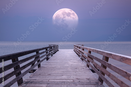 Full moon and viewpoint platform at sea dusk