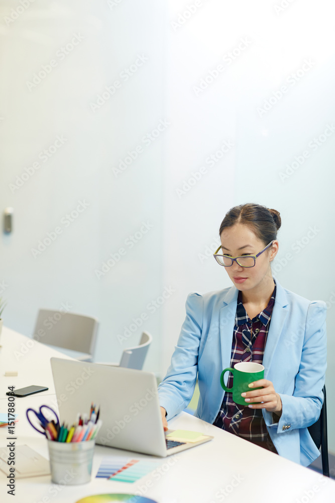 Businesswoman with mug working online in office Businesswoman with mug working online in office