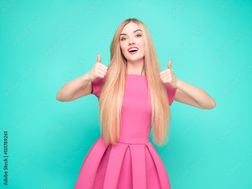 Fototapeta premium The beautiful young woman in pink mini dress posing at studio