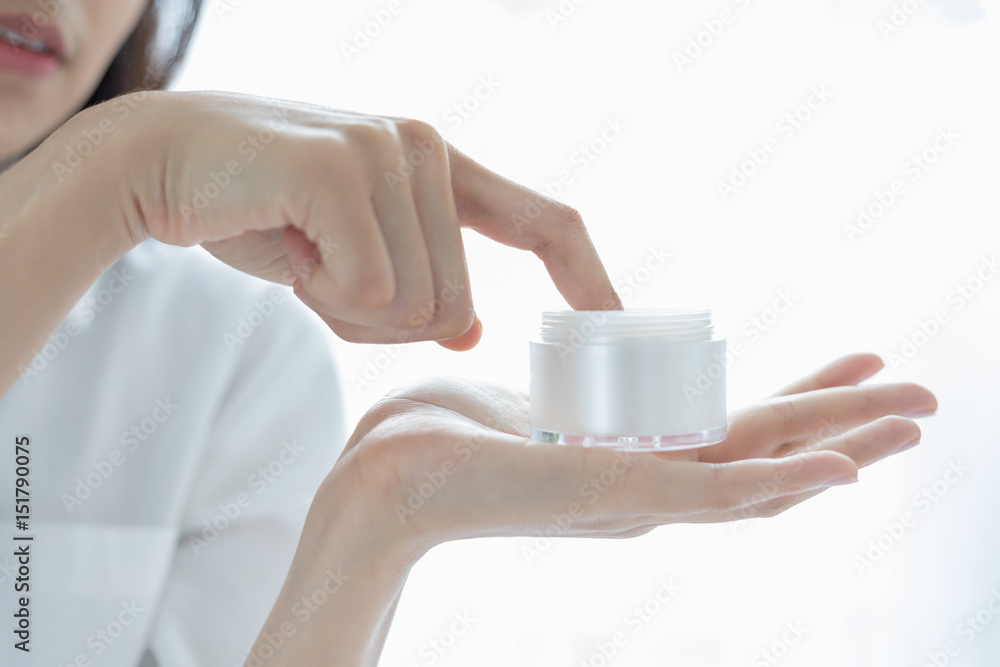 A beautiful woman asian using a skin care product, moisturizer or lotion taking care of her dry complexion. Moisturizing cream in female hands . A beautiful woman asian using a skin care product, moisturizer or lotion taking care of her dry complexion. Moisturizing cream in female hands .