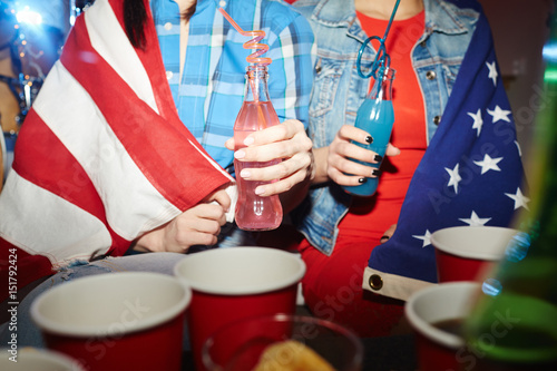 Canvas Print Mid-section portrait of two teenage girls drinking cocktails at late night party